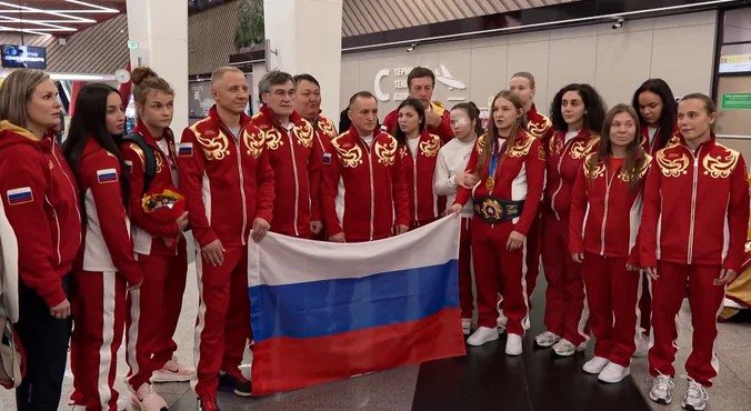 С цветами, флагами и балалайкой: как встретили сборную России по борьбе в Шереметьеве?